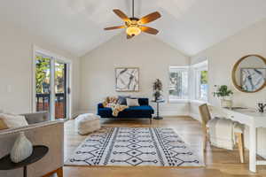 Living room with vaulted ceiling, baseboards, a ceiling fan, and wood finished floors