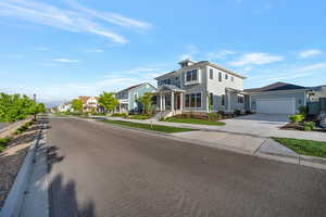 View of front of property featuring concrete driveway, an attached garage, and a residential view