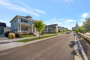 View of asphalt road with sidewalks, a residential view, and curbs