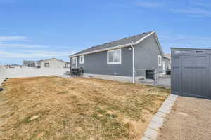 Back of property featuring a storage shed, a lawn, an outbuilding, and a fenced backyard