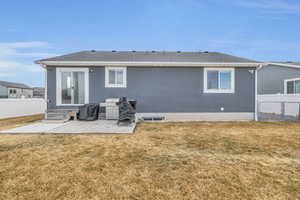 Back of house with a yard, a fenced backyard, and a patio area
