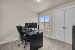 Office with visible vents, baseboards, and carpet floors