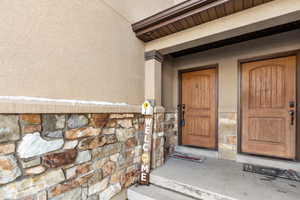 Property entrance with stucco siding and stone siding