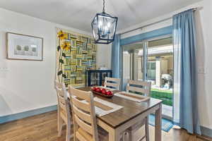 Dining area featuring wood finished floors, baseboards, and a chandelier