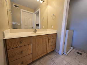 Bathroom with wooden vanity and tile patterned flooring