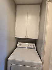 Laundry area featuring cabinet space and washer / dryer