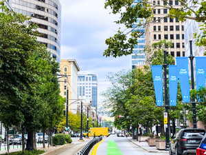 View of street with traffic lights, sidewalks, curbs, and street lighting