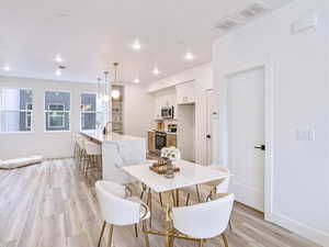 Dining area with baseboards, light wood-style floors, visible vents, and recessed lighting