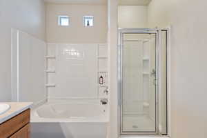 Full bath with a bathing tub and a stall shower