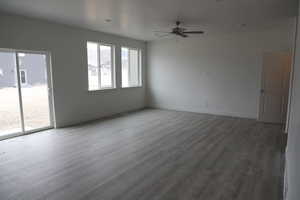 Spare room featuring wood finished floors, baseboards, and ceiling fan