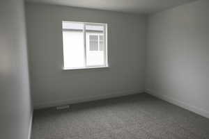 Spare room with carpet flooring, baseboards, and visible vents