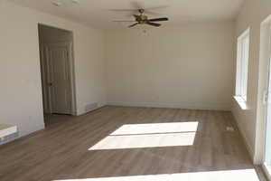 Unfurnished room with visible vents, light wood-style flooring, baseboards, and a ceiling fan