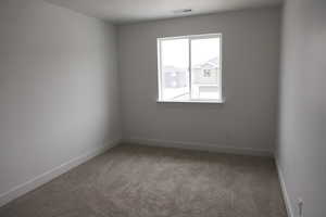 Carpeted empty room featuring visible vents and baseboards