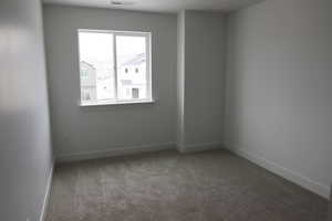 Empty room featuring carpet flooring and baseboards