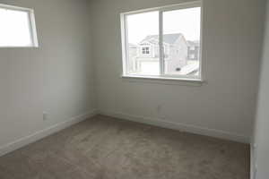 Unfurnished room featuring baseboards and light carpet