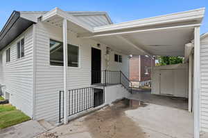 Exterior space with a carport, an outdoor structure, and a storage shed