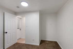 Empty room featuring baseboards, light carpet, and ornamental molding