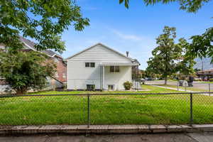 View of home's exterior with a fenced backyard and a yard