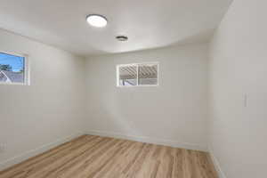 Empty room featuring visible vents, baseboards, and light wood finished floors