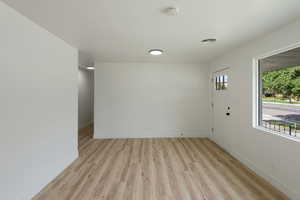 Spare room with visible vents, light wood-type flooring, and baseboards