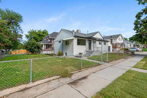 Bungalow-style house with a fenced front yard, a front yard, and a gate