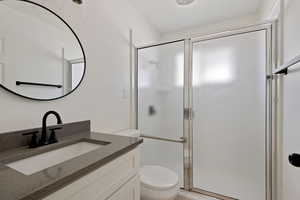 Full bath with a shower stall, toilet, and vanity