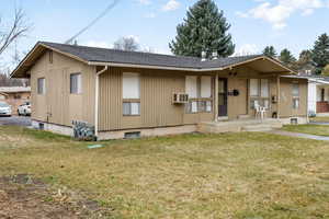 View of front of home with roof with shingles and a front yard