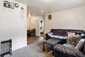 Carpeted living room with visible vents and baseboards