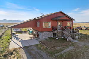 View of front of property with stone siding, a mountain view, and driveway
