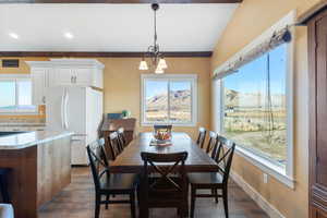 Dining space featuring a wealth of natural light, a chandelier, baseboards, and dark wood-style floors