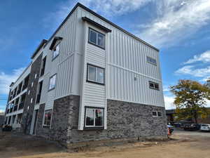 View of property exterior with board and batten siding and brick siding