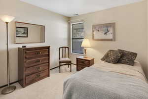 Bedroom featuring visible vents, light carpet, and baseboards