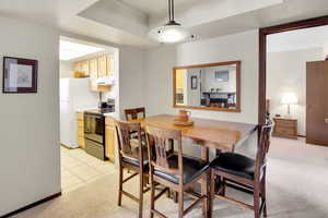 Dining space featuring light carpet and light tile patterned floors