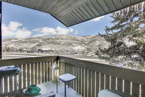 Snow covered back of property featuring a mountain view