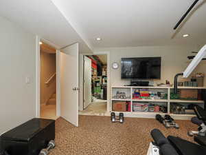 Exercise room featuring recessed lighting and access to stairway and storage room