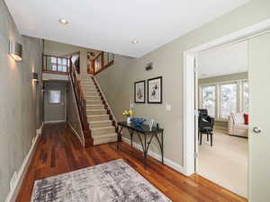Foyer featuring stairway, hardwood floors, front entry office or formal room