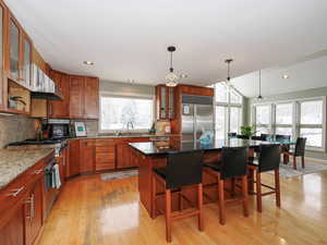 Kitchen opens to great room, dining, soaring vaults and windows.