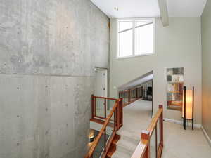 Stairway landing with sunny den or artists nook, glass walls and skylights abound here