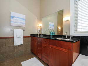 Full bathroom featuring double vanity, and tile surround