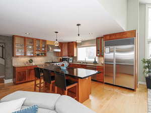 Kitchen with hardwood floors, stainless steel appliances, entertainers bar and rich hardwood cabinets