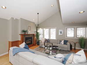 Great room features inviting fireplace, and high vaulted ceiling