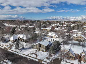 Snowy aerial view featuring a mountain view and a residential view