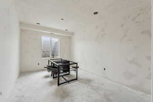 Interior space featuring a textured ceiling and concrete floors