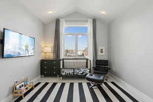Carpeted bedroom featuring baseboards and lofted ceiling