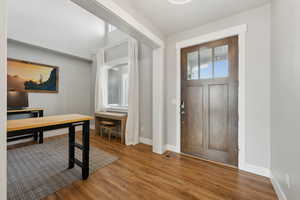 Entrance foyer with visible vents, baseboards, and wood finished floors
