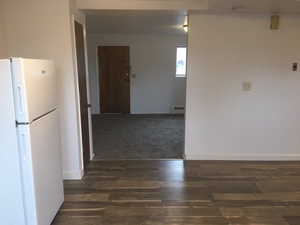 Interior space with baseboards, baseboard heating, and wood finished floors