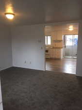 Unfurnished room featuring a textured ceiling and carpet
