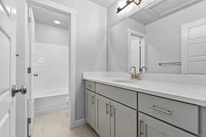 Bathroom featuring tile patterned floors, toilet, tub / shower combination, and vanity