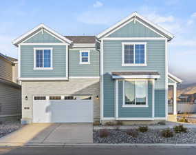 View of front of house with driveway, board and batten siding, and an attached garage