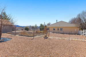 View of yard featuring a mountain view, fence, and a garden